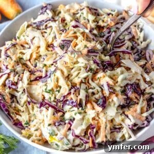 Wholesome & Creamy Greek Yogurt Coleslaw 9 Bowl of healthy coleslaw with Greek yogurt surrounded by ingredients on a wooden table, emphasizing freshness and vibrant colors.