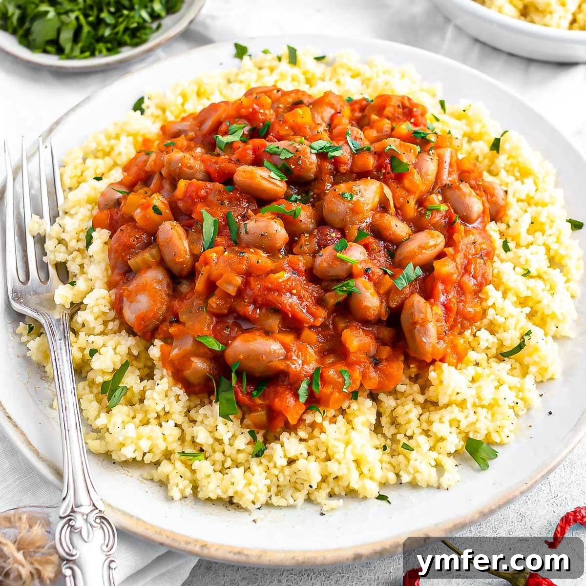 19 Simple Bean Recipes to Slash Your Weekly Food Bill 14 Rustic borlotti bean stew with a fork, emphasizing its hearty and comforting appeal.