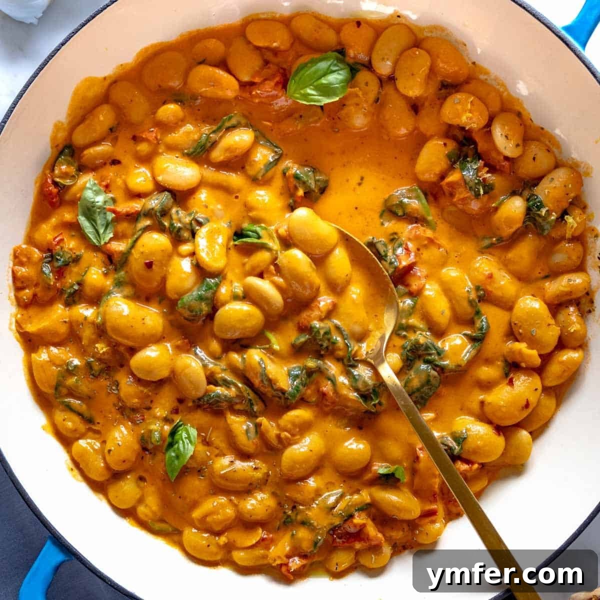19 Simple Bean Recipes to Slash Your Weekly Food Bill 16 Lush Marry Me Butter Beans served in a beautiful blue skillet, adorned with fresh herbs, ready to impress.