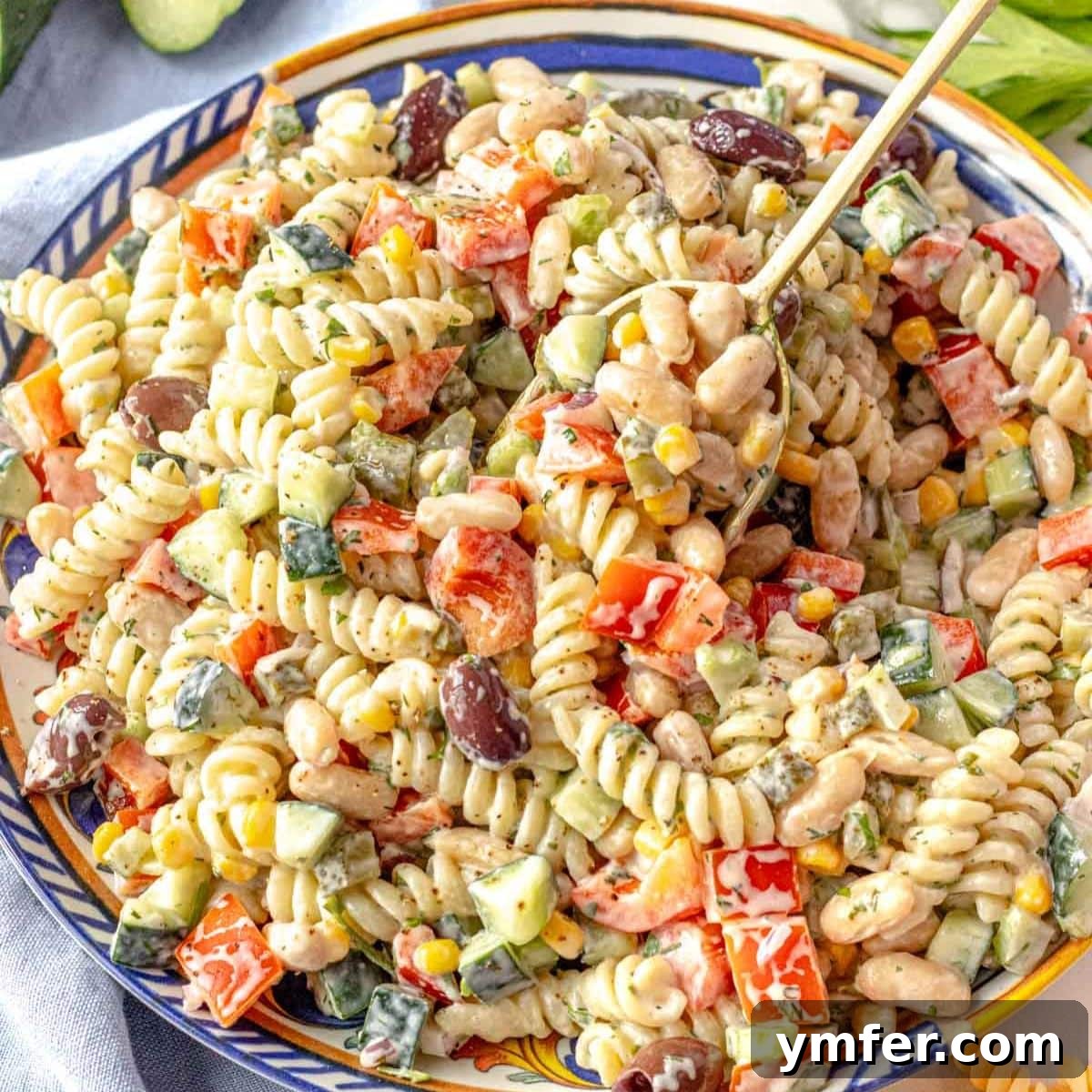 19 Simple Bean Recipes to Slash Your Weekly Food Bill 6 Creamy Greek yogurt pasta salad with cannellini beans and fresh vegetables in a serving bowl, a nutritious and flavorful lunch option.