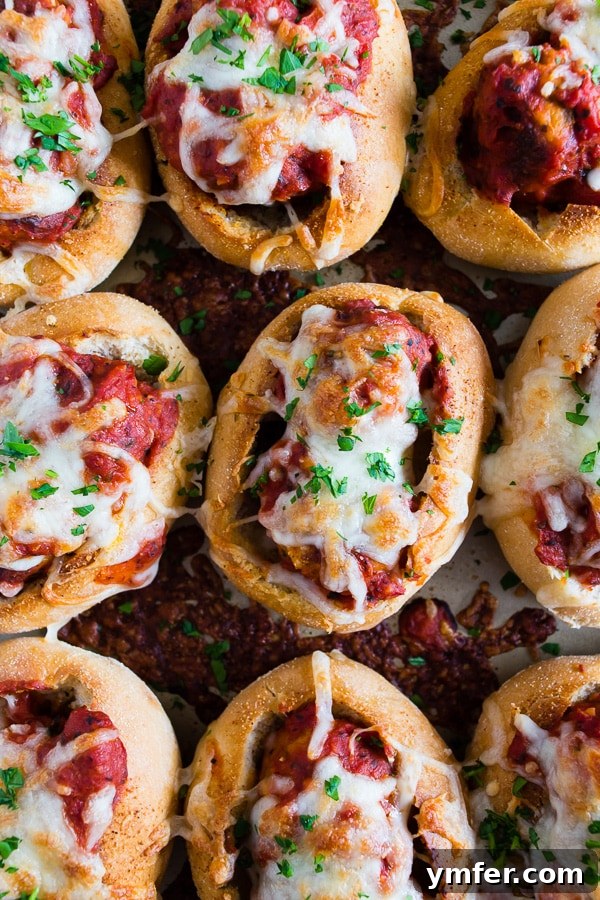 Cheesy Chicken Parm Meatball Sliders 2 Mini Chicken Parmesan Meatball Subs served with a sprinkle of fresh parsley on top, showcasing their cheesy, saucy goodness, ready for game day.