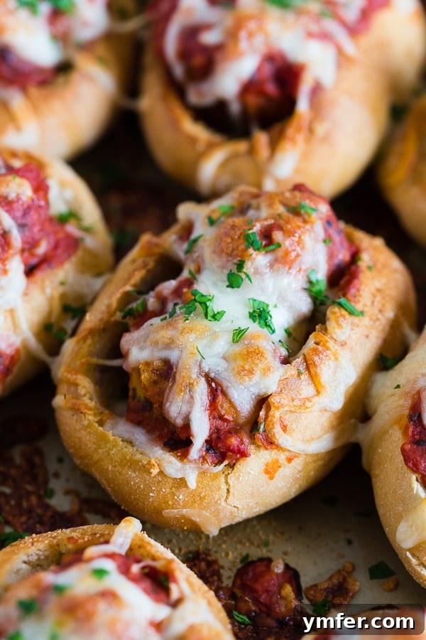 Cheesy Chicken Parm Meatball Sliders 3 A sheet pan filled with golden-brown Mini Chicken Parmesan Meatball Subs, perfectly baked and ready to be served as delicious game day appetizers.