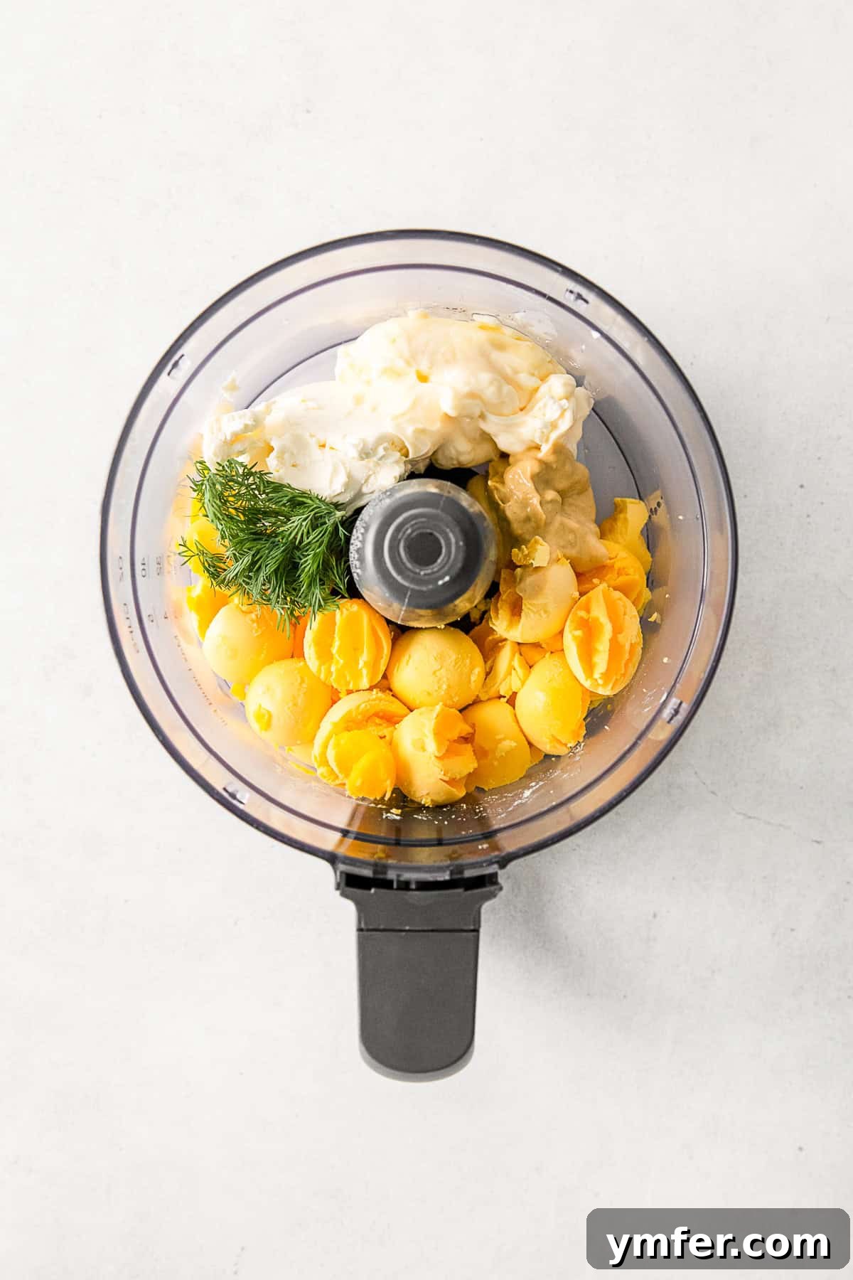 Heirloom Deviled Eggs 4 All the essential ingredients for Classic Deviled Eggs gathered in a food processor bowl, ready for blending.