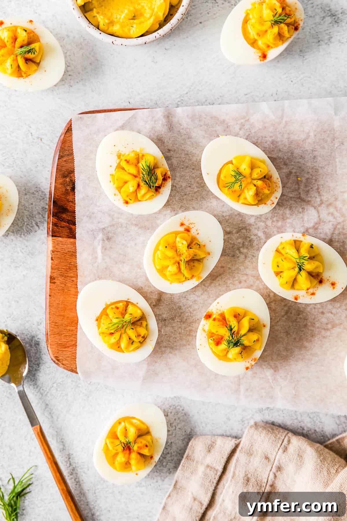 Heirloom Deviled Eggs 5 Classic Deviled Eggs elegantly arranged on a rustic wooden cutting board, ready for serving.