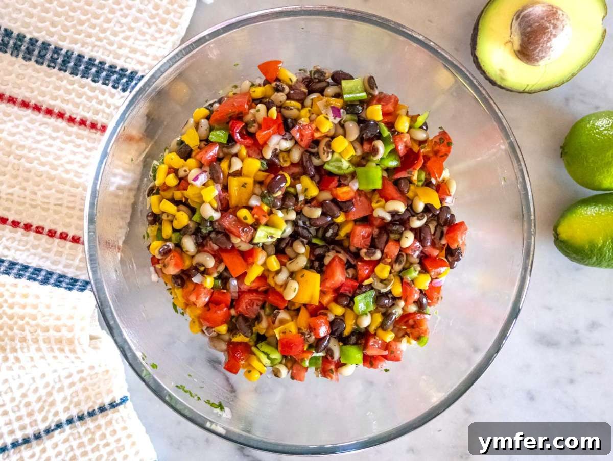 Southwestern Marinated Bean Medley 7 Step 3 Tossing Cowboy Caviar salad and adjusting flavors before chilling in the fridge.
