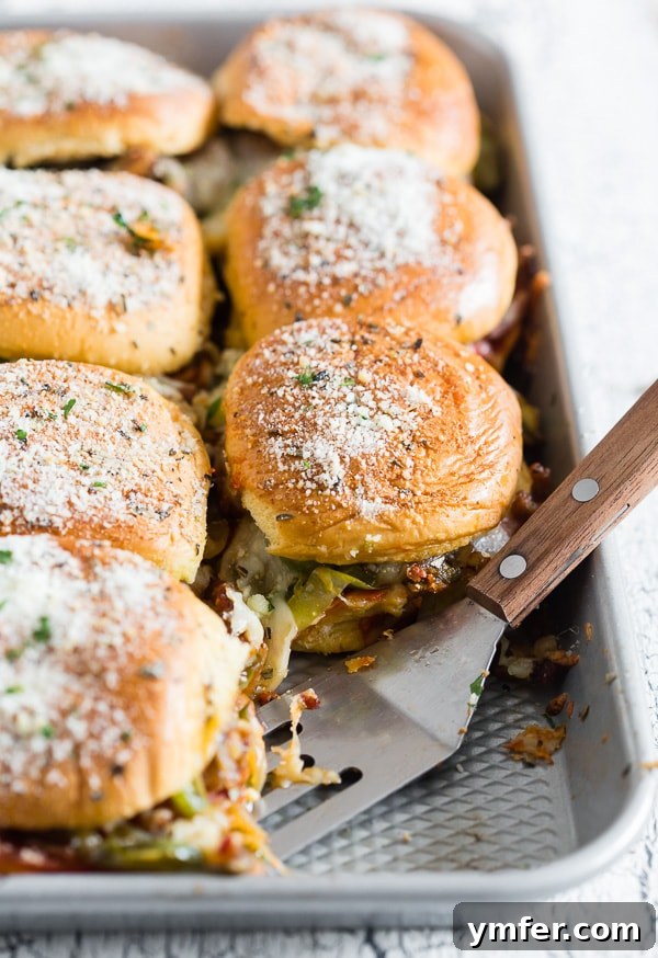 A pan full of Baked Supreme Pizza Sliders, ready to be served, showing the golden tops and inviting cheesy texture.