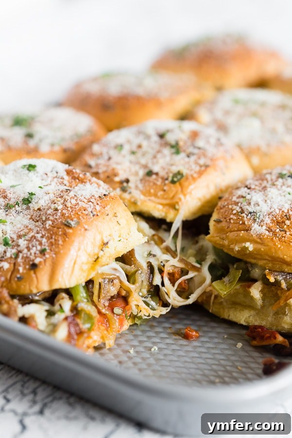 Baked Supreme Pizza Sliders cooling in a sheet pan after coming out of the oven, highlighting their perfect golden tops and readiness to be served.