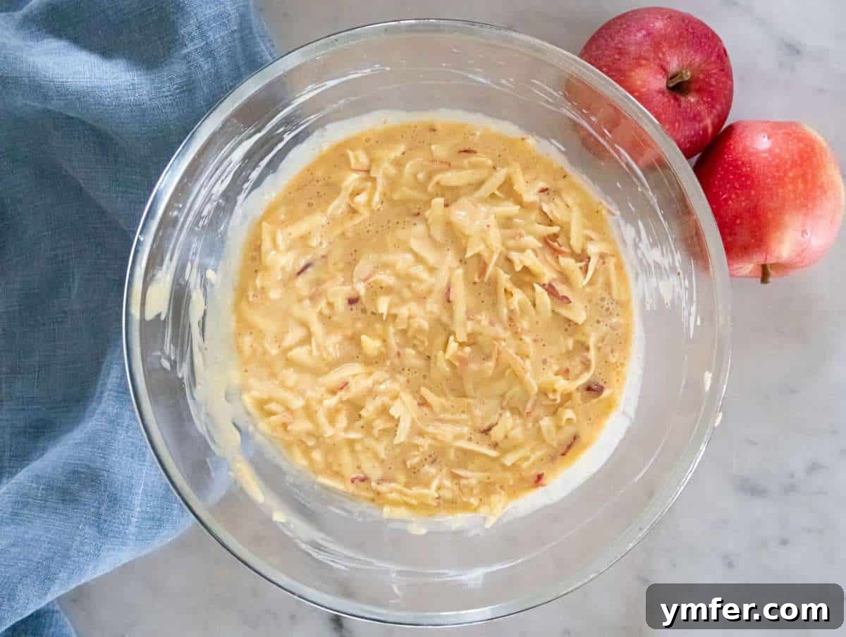 Protein Packed Cinnamon Apple Muffins 6 Step 2 greek yogurt peanut butter eggs sugar and grated apples whisked in large bowl.