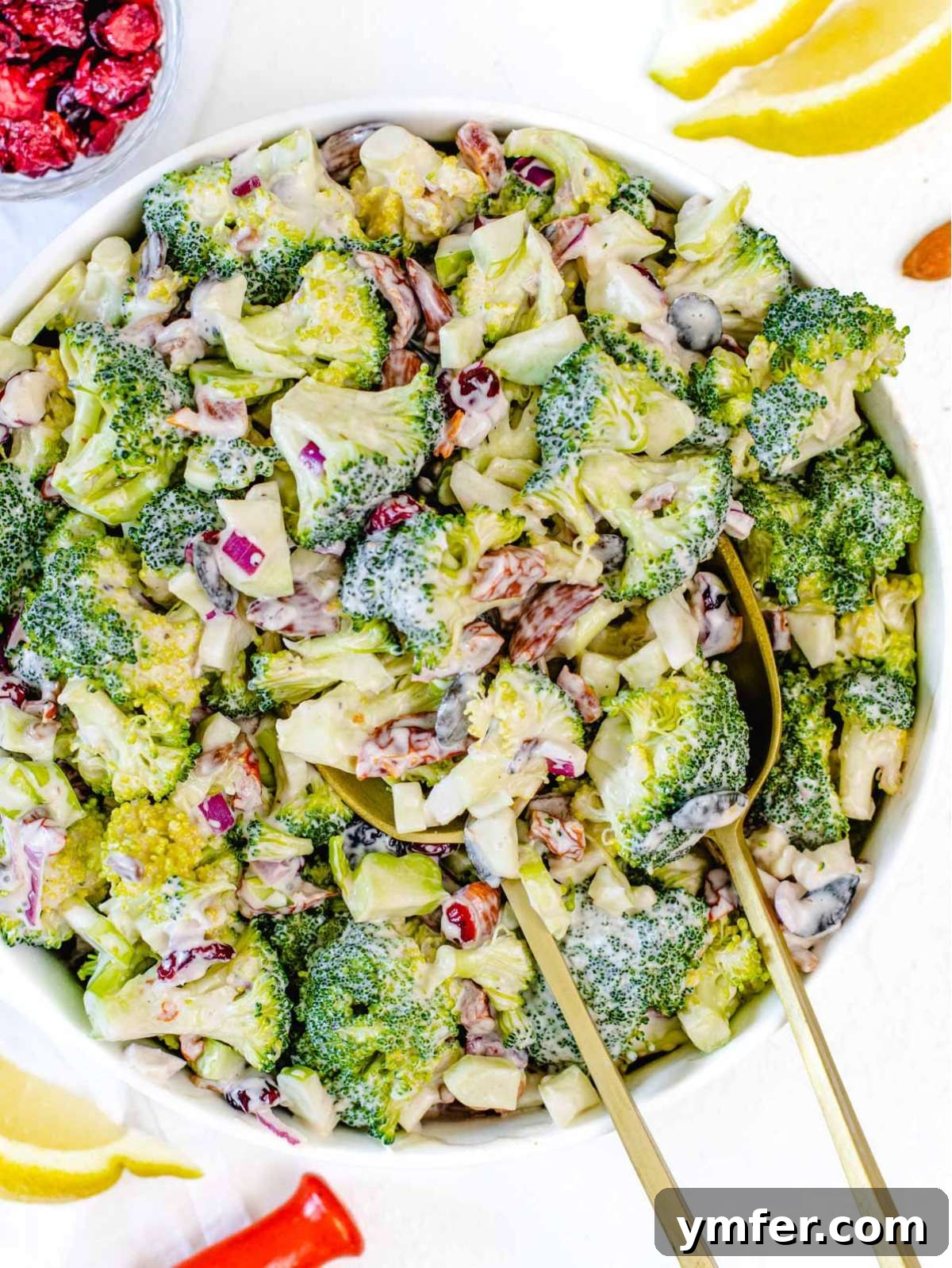 Top down healthy broccoli salad with sun dried tomatoes nuts and yogurt dressing.