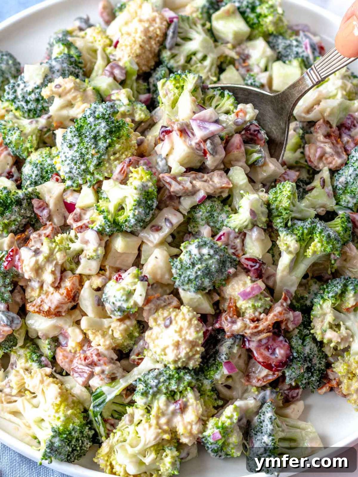 Close up Greek yogurt broccoli salad with cranberries almonds and creamy dressing.