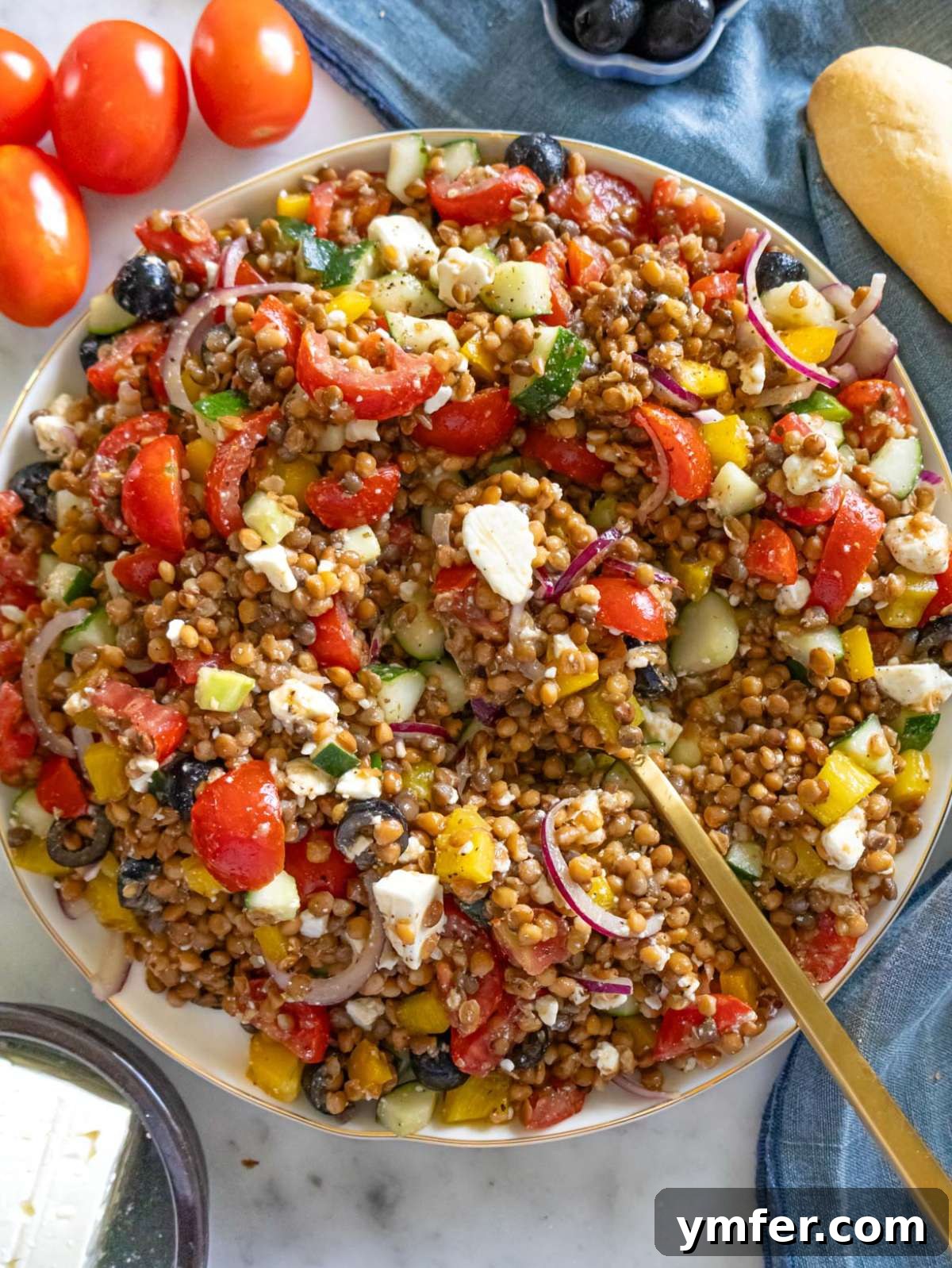 Greek Lentil Salad with a Zesty Marinade Dressing 2 Top down Greek lentil salad on a large platter with colorful vegetables and feta.