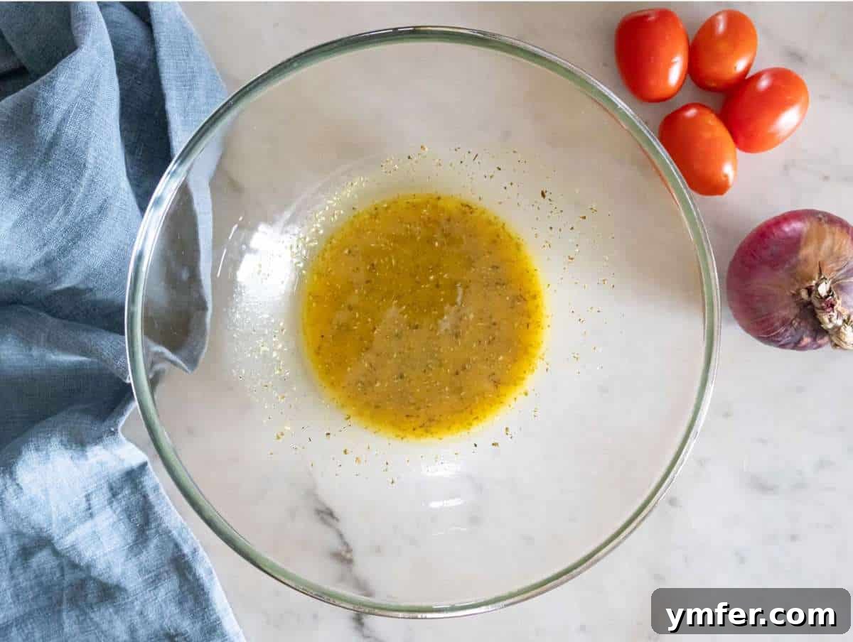Greek Lentil Salad with a Zesty Marinade Dressing 5 Step 1 Whisking olive oil vinegar mustard honey and oregano to make dressing for Greek lentil salad.