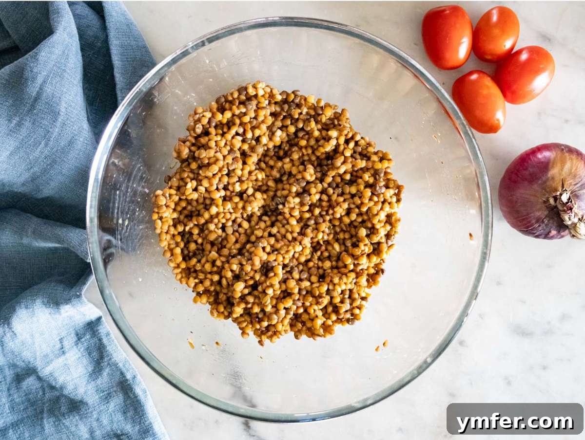 Greek Lentil Salad with a Zesty Marinade Dressing 6 Step 2 Lentils marinating in dressing with herbs for extra flavor before adding vegetables.