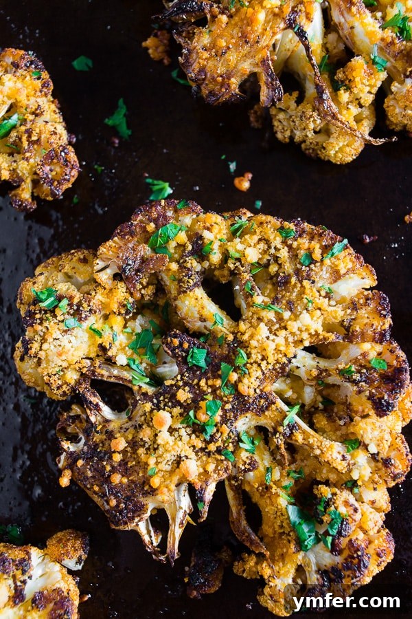 Golden Cajun Parmesan Cauliflower Steaks 4 A close-up of a Parmesan Cajun Spiced Cauliflower Steak on a sheet pan before cooking, showing the vibrant seasoning evenly coated over the florets.