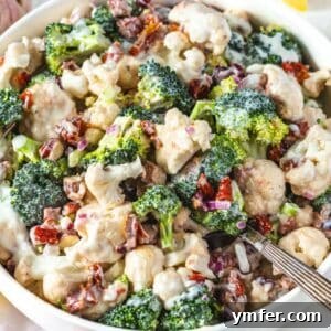 Creamy Broccoli Cauliflower Salad with Tangy Greek Yogurt 9 Fresh healthy broccoli cauliflower salad with Greek yogurt dressing served in a bowl with silver spoon.