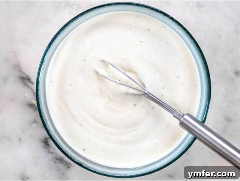 Creamy Broccoli Cauliflower Salad with Tangy Greek Yogurt 10 Step 2 Whisking Greek yogurt dressing with vinegar mustard and honey for creamy broccoli cauliflower salad.