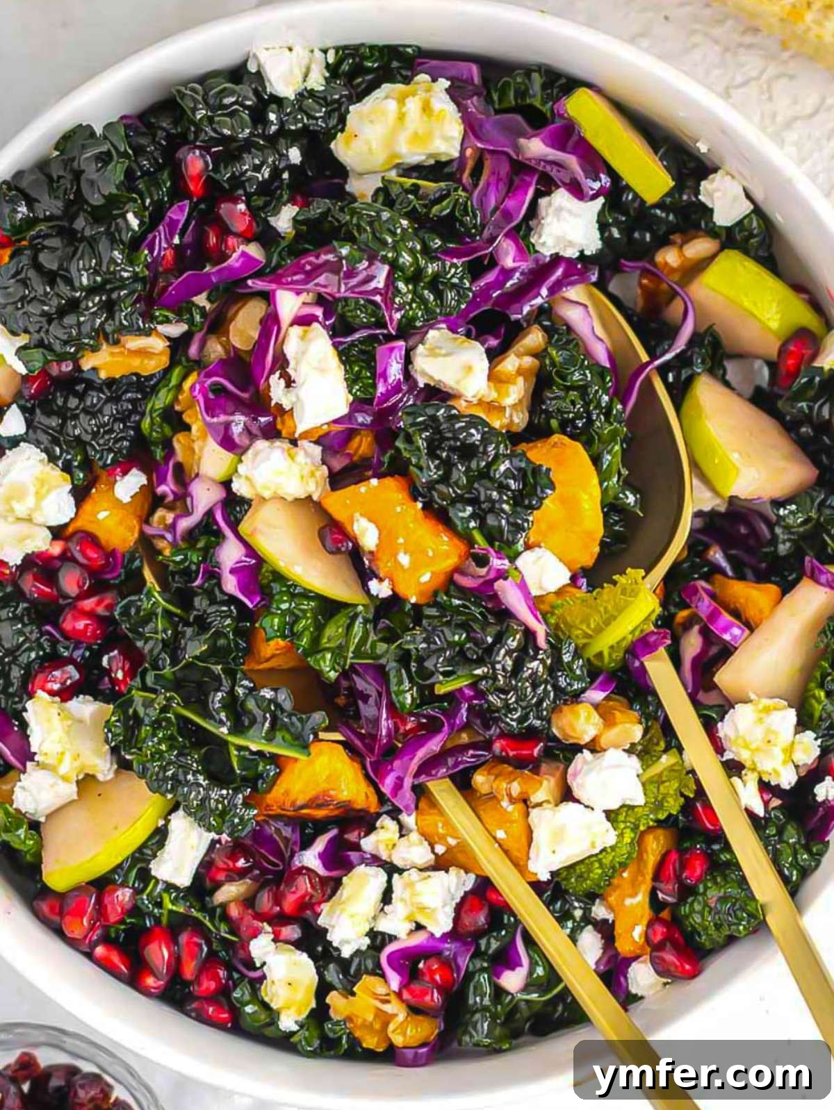 Nourishing Butternut Squash Kale Salad 4 Healthy butternut squash kale salad with honey mustard dressing walnuts apple and pomegranate close up.