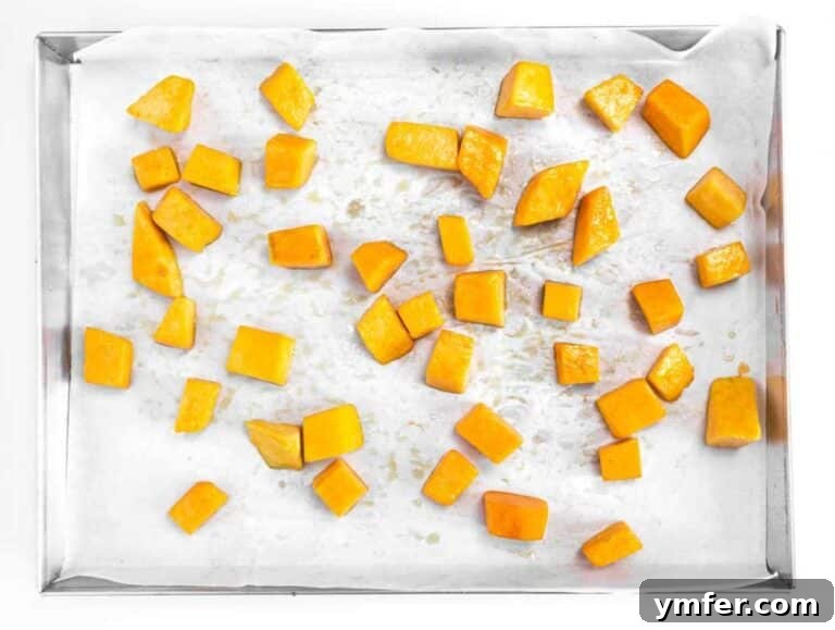 Nourishing Butternut Squash Kale Salad 10 Step 1 Cubes of butternut squash roasting on a baking tray until tender and golden.