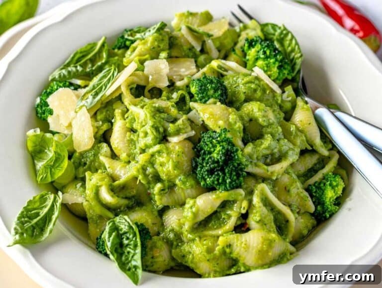 Step 4 Bowl of smashed broccoli pasta topped with basil leaves and shaved parmesan.