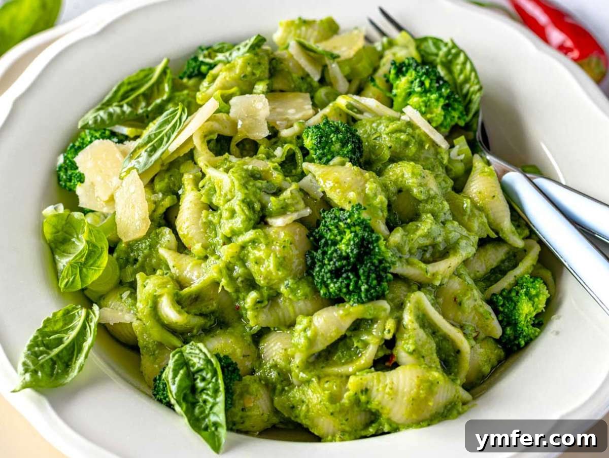 Step 4 Bowl of smashed broccoli pasta topped with basil leaves and shaved parmesan.