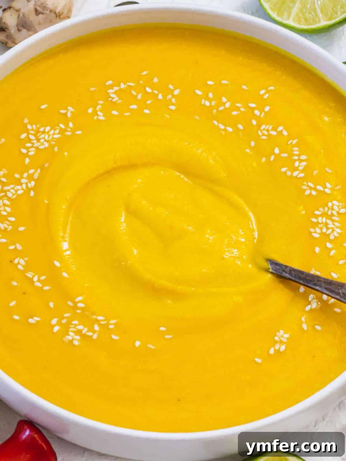 Nourishing Creamy Coconut Pumpkin Soup for Fall 2 Creamy coconut pumpkin soup served in a bowl with a slice of lime on top, evoking cozy fall vibes.