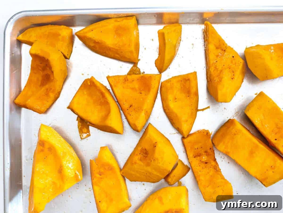 Nourishing Creamy Coconut Pumpkin Soup for Fall 5 Step 1 Raw pumpkin chunks neatly spread on a baking sheet, seasoned and ready for roasting to develop deep flavors for the soup.