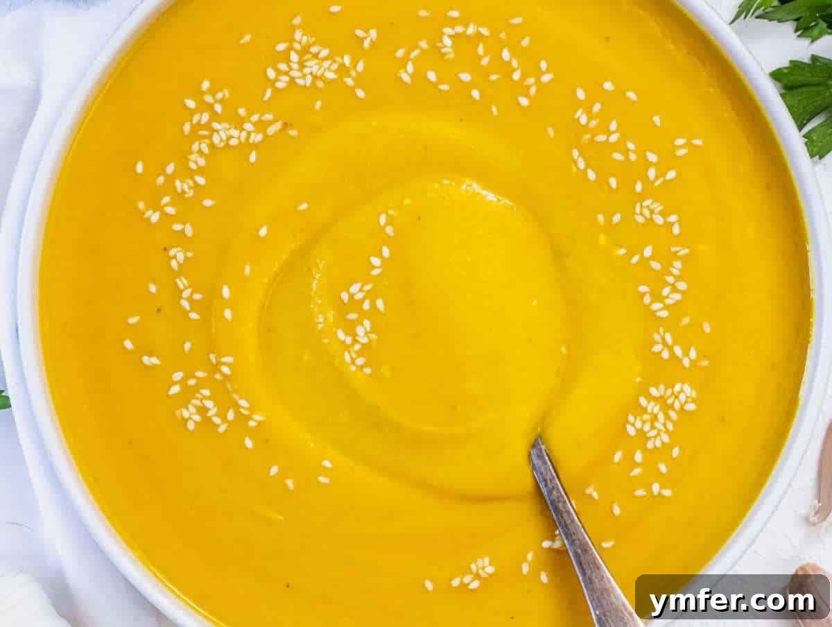 Nourishing Creamy Coconut Pumpkin Soup for Fall 9 Step 5 Vibrant coconut pumpkin soup served in elegant bowls, beautifully garnished with fresh lime wedges and cilantro, inviting a delightful culinary experience.