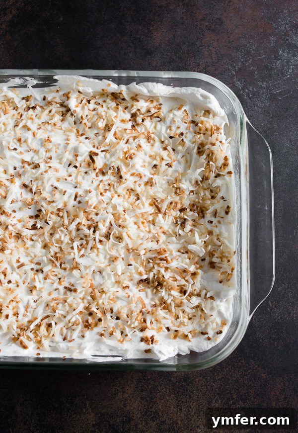 Coconut Cloud Tres Leches 3 Toasted Coconut Tres Leches Cake in a 9x13 pan, soaked in milk and ready for topping.