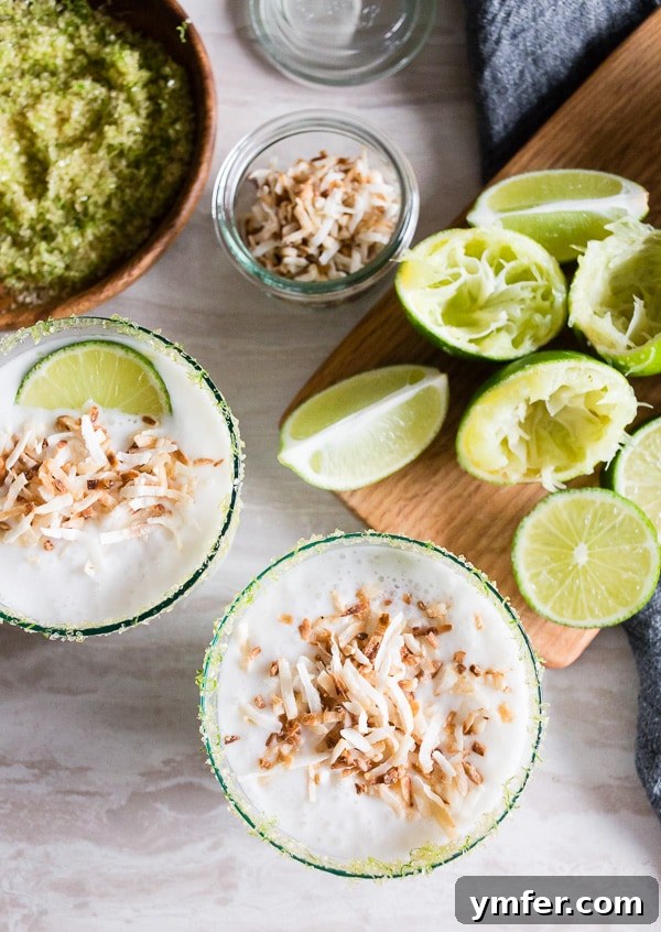 Tropical Coconut Lime Margarita Frost 2 A refreshing coconut lime frozen margarita, garnished with vibrant lime slices, epitomizing the perfect summer drink.