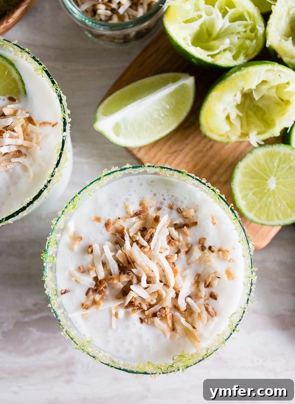 Tropical Coconut Lime Margarita Frost 4 A coconut lime frozen margarita garnished with toasted coconut and lime, ready to be enjoyed.