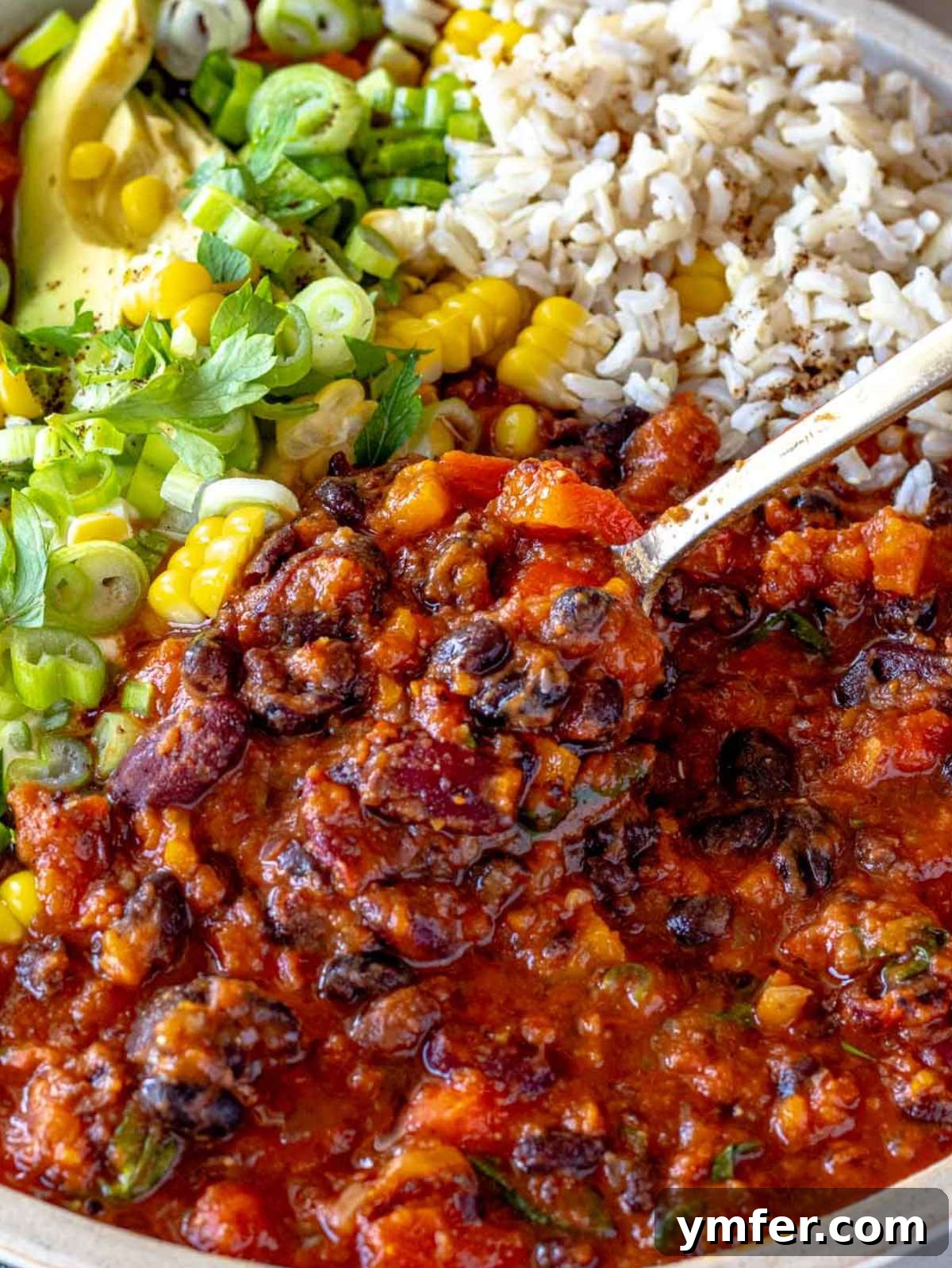 Protein Powerhouse Chili With Beans 2 Hearty chili with beans in a bowl topped with avocado and cilantro.