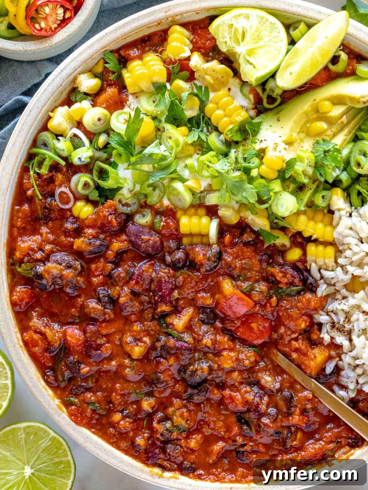 Protein Powerhouse Chili With Beans 4 antro Top down view of chili with beans served with corn avocado and lime.