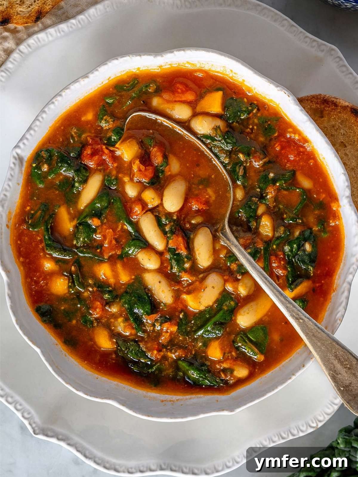 Heart-Smart Mediterranean Kale Soup 2 Close-up of Mediterranean kale soup showing tender kale, white beans, and hearty tomato broth.