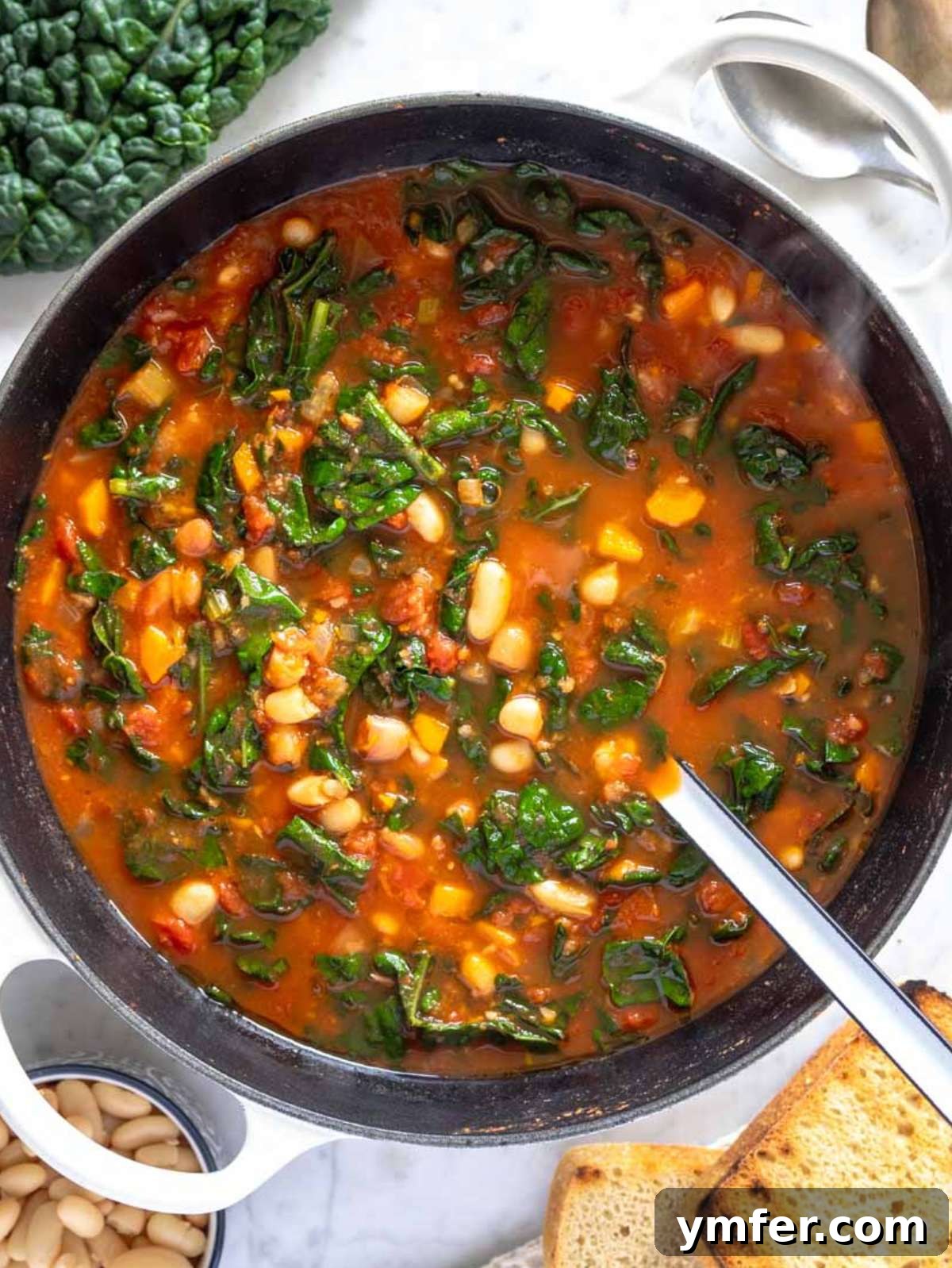Heart-Smart Mediterranean Kale Soup 4 Top-down view of Mediterranean kale soup with bread and olive oil drizzle.