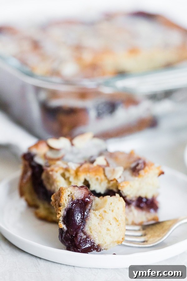Old-Fashioned Cherry Fritter Cake 5 A fork holding a bite of cherry fritter cake.