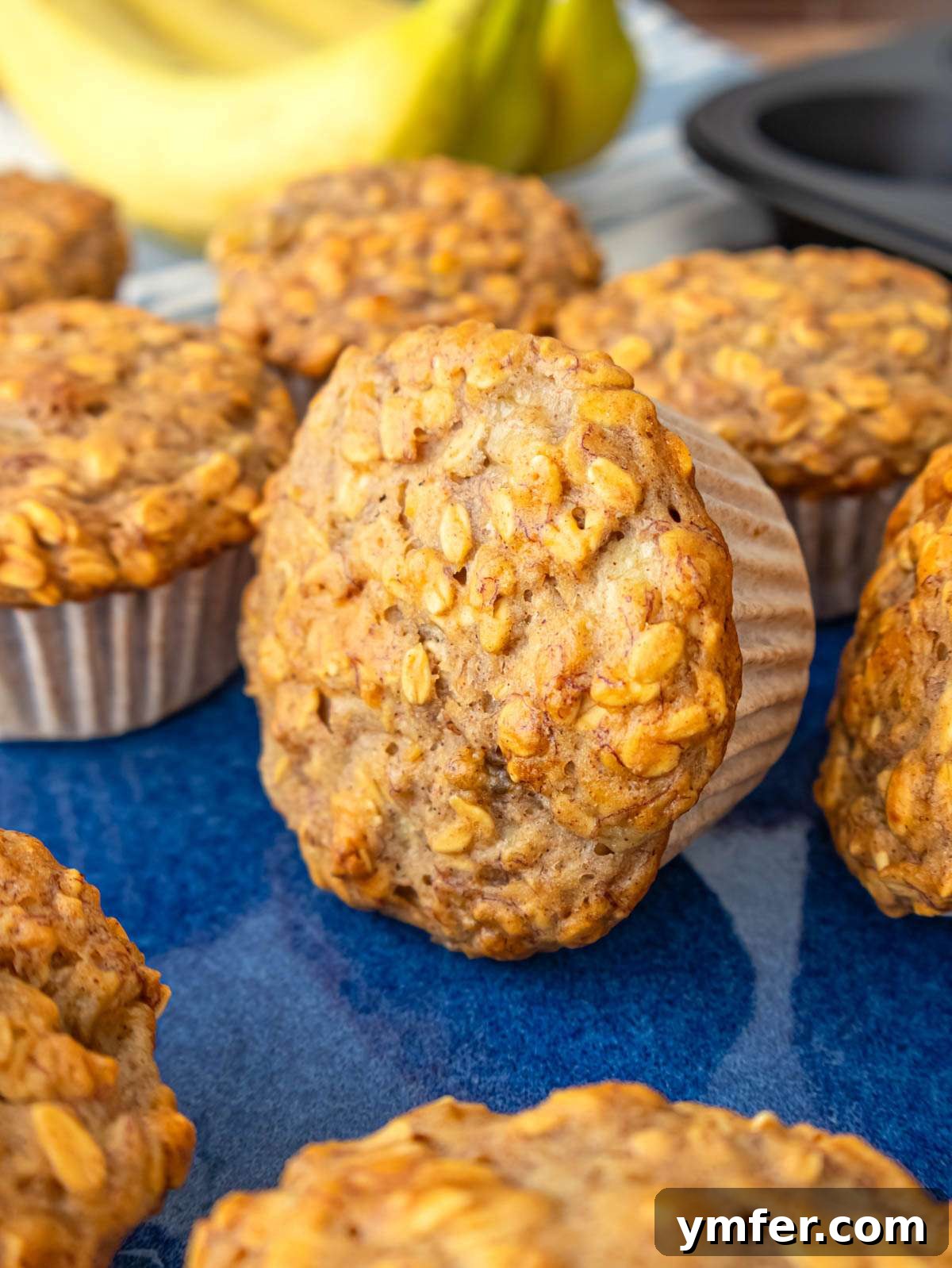 Wholesome Oil-Free Banana Oat Muffins 2 Close up of soft banana oatmeal muffins with golden oats on top.
