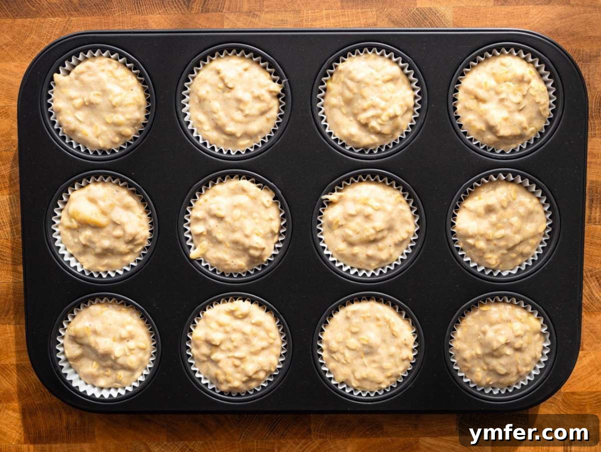 Wholesome Oil-Free Banana Oat Muffins 7 Step 3 Filling muffin pan with banana oatmeal batter before baking.