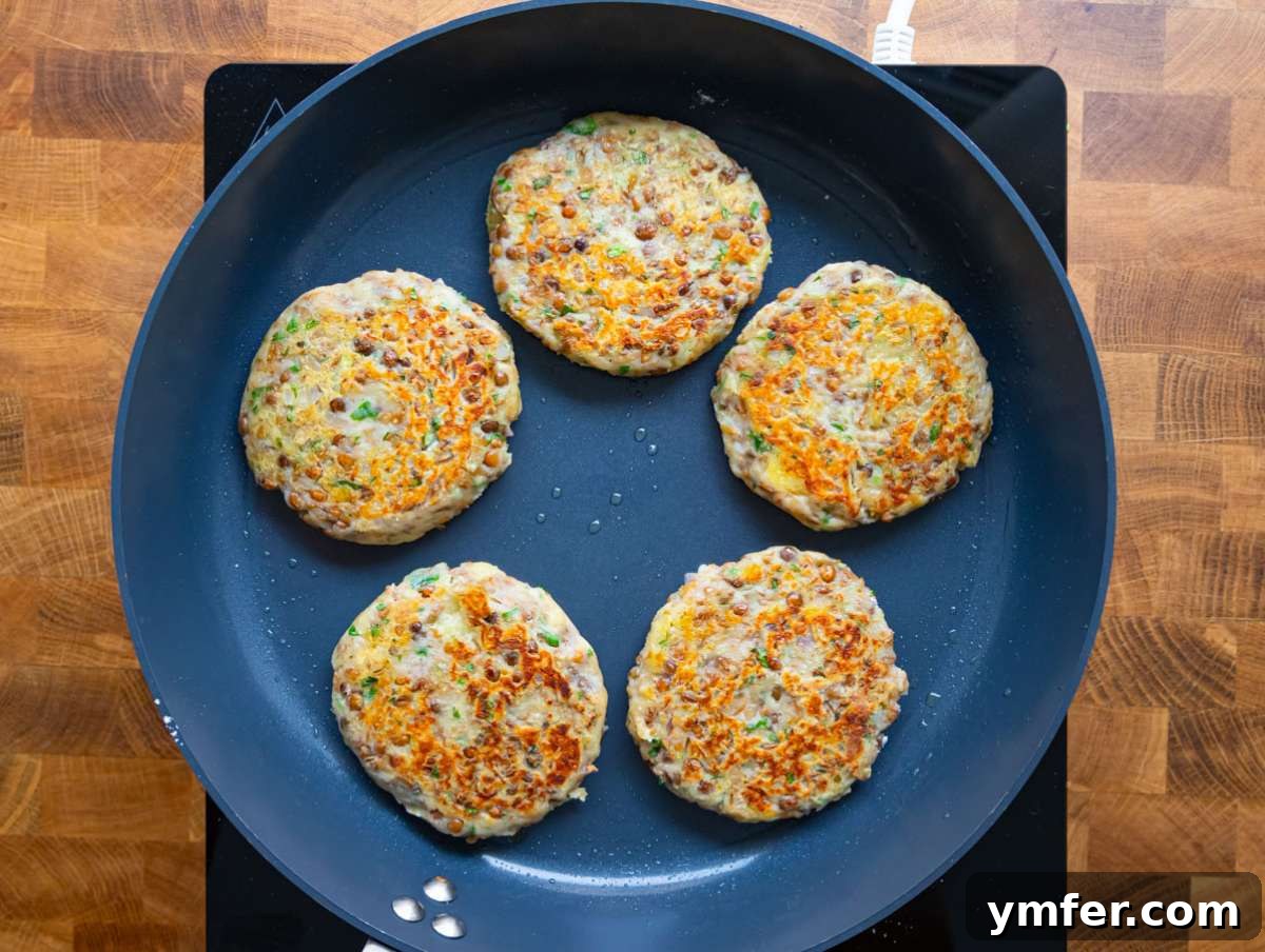 Step 3: Lentil potato patties sizzling in a nonstick skillet, developing a golden-brown and crispy crust.