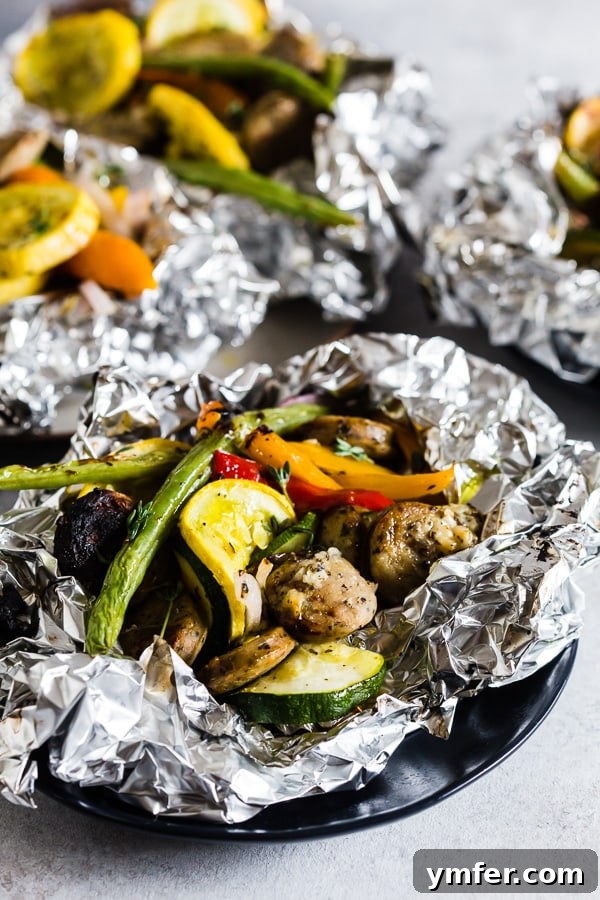 Hearty Chicken Sausage and Roasted Veggie Foil Bundles 4 Sliced chicken sausage and colorful vegetables seasoned with herbs and olive oil, ready for foil packet assembly.