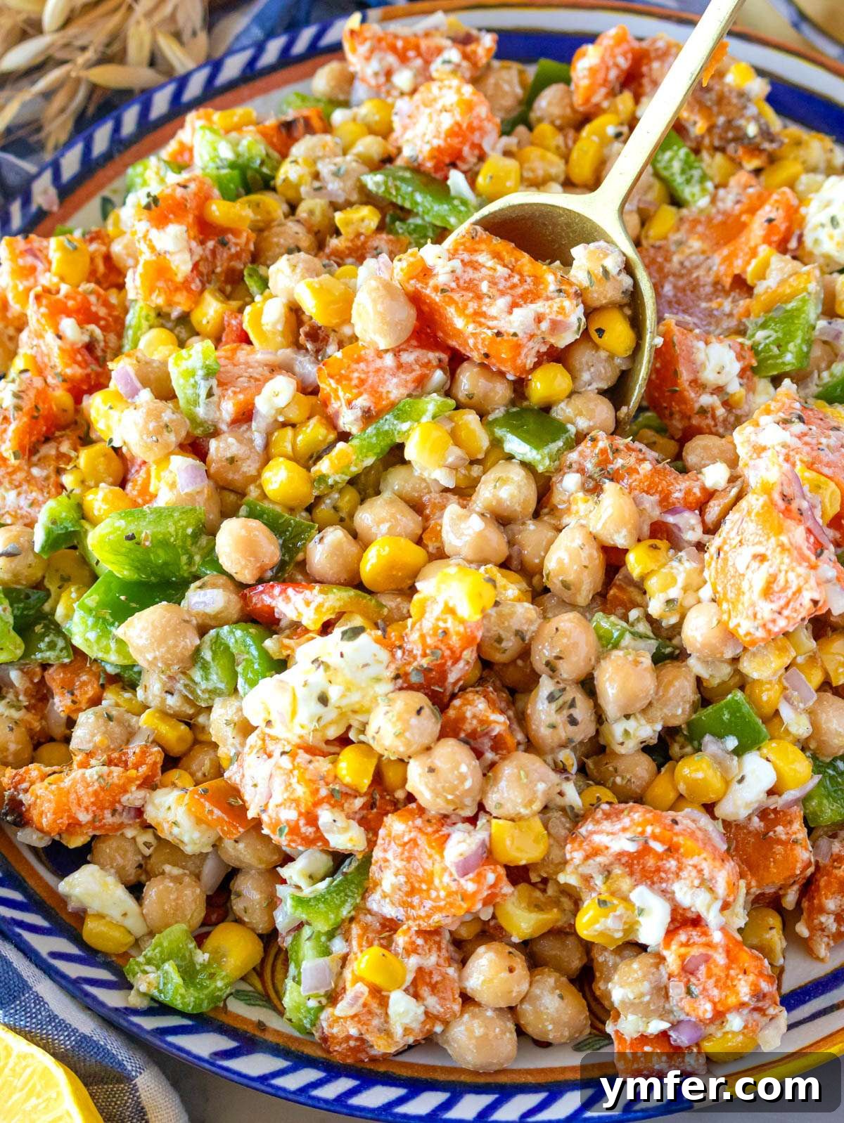 Nourishing Sweet Potato Chickpea Salad 2 Close up of dense chickpea sweet potato salad with feta and honey mustard dressing, showcasing vibrant colors and textures.