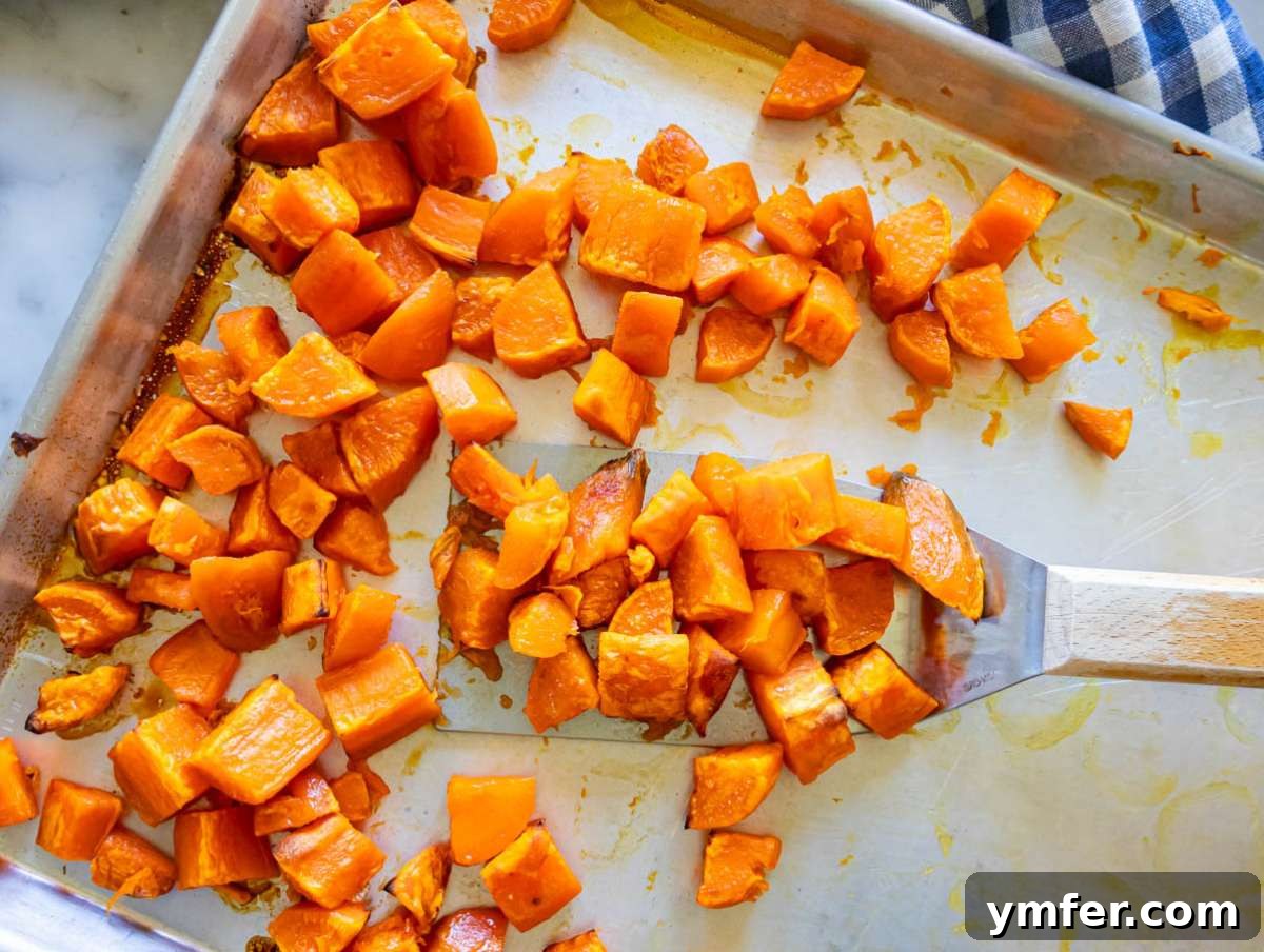 Nourishing Sweet Potato Chickpea Salad 5 Step 1: Fork tender roasted sweet potatoes after 25 minutes in the oven, showing golden edges.
