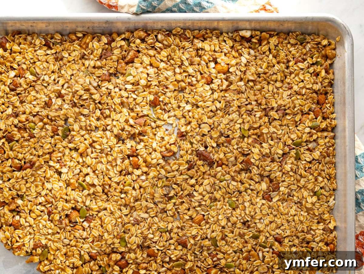 Wholesome & Crispy Granola: Oil-Free Clusters Done Right 7 Step 3 Granola slab pressed firmly on baking sheet before baking for big crunchy clusters.