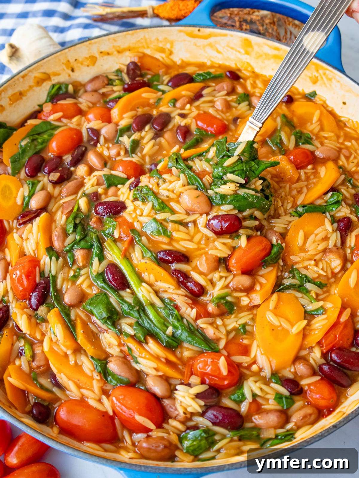 Mediterranean Orzo with Beans A Wholesome One-Pan Meal 2 Finished orzo and beans close up showing creamy texture with spinach and tomatoes.