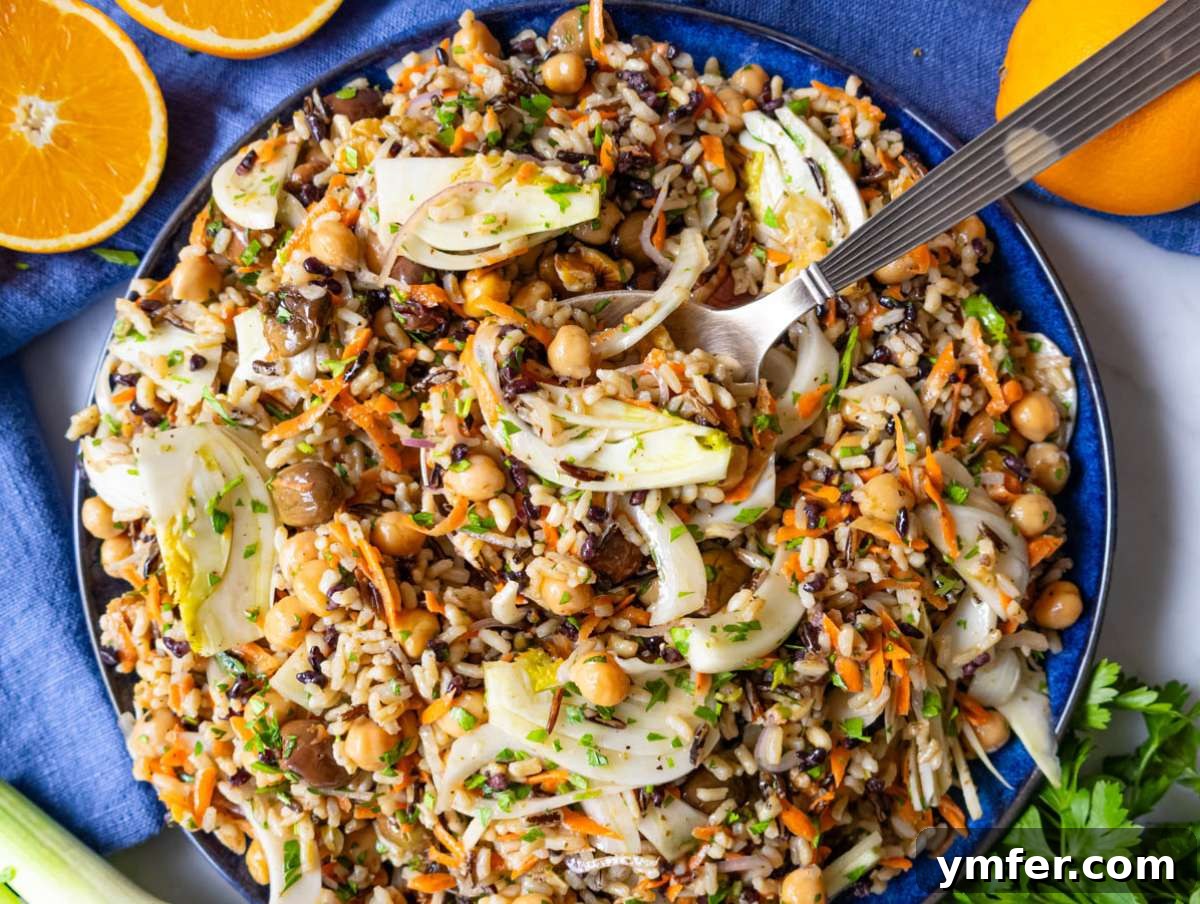 Mediterranean Wild Rice Salad for Healthy Meal Prep 8 Step 4 Mediterranean diet friendly wild rice salad served on a blue platter with a silver spoon.