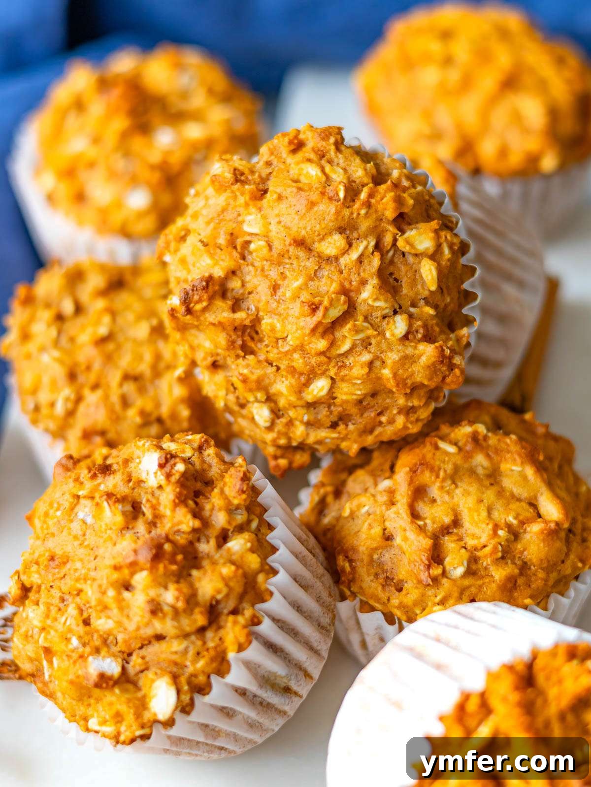 Wholesome Oil-Free Sweet Potato Oatmeal Muffins 2 Stack of healthy sweet potato oatmeal muffins topped with visible oats for added texture.