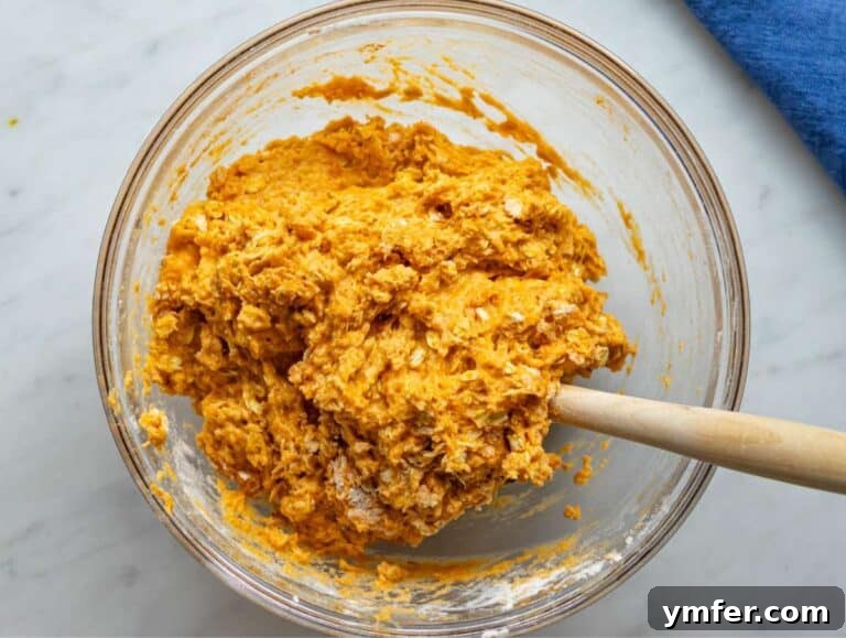 Wholesome Oil-Free Sweet Potato Oatmeal Muffins 13 Step 3 Dry ingredients added to bowl creating thick muffin batter with oats and sweet potato.