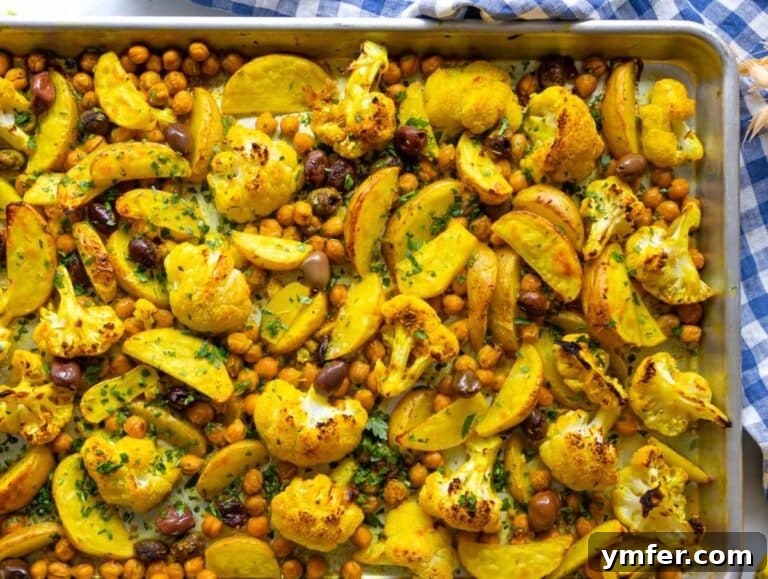 Golden Turmeric Cauliflower and Chickpea Sheet Pan Dinner 12 Step three roasted turmeric vegetables coming out of oven golden and tender.