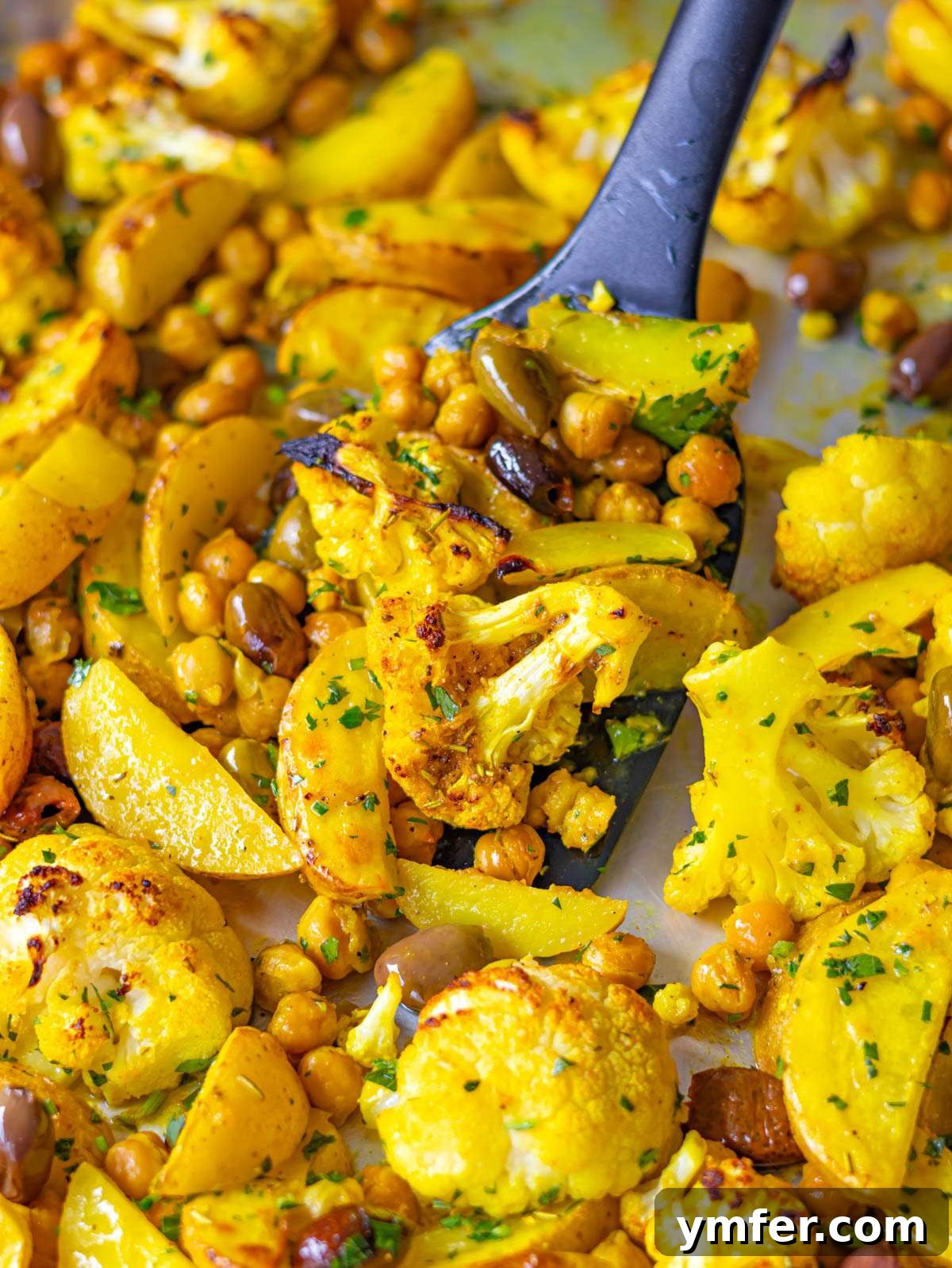 Golden Turmeric Cauliflower and Chickpea Sheet Pan Dinner 4 Finished dish close up golden turmeric cauliflower and chickpeas with lemon and parsley.