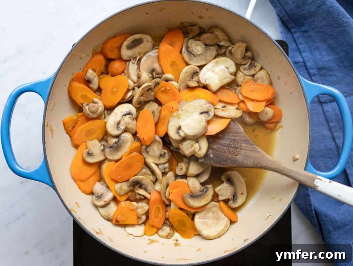 Healthy Mediterranean One-Pot Three Bean Orzo Soup 5 Step 1 Step sautéing onion carrots and mushrooms for Mediterranean three bean orzo soup.