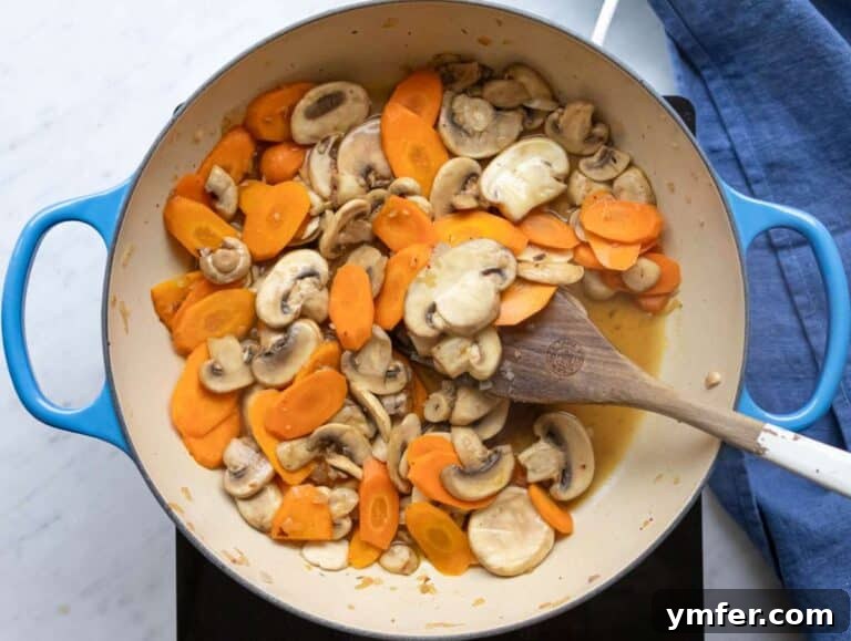 Step 1 Step sautéing onion carrots and mushrooms for Mediterranean three bean orzo soup.